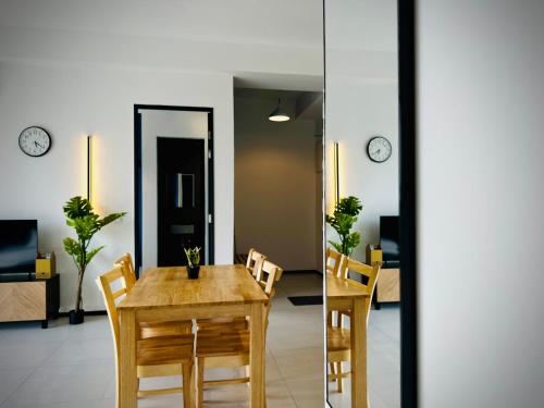 a dining room with a table and chairs and clocks at Urban Suite Cozy Family Homestay at Georgetown by URBAN STAYCATION HENG LOD in Jelutong