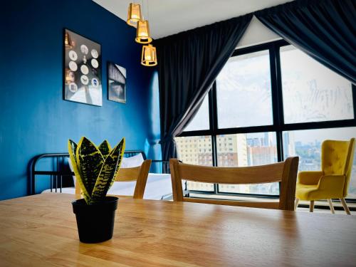 a dining room table with a potted plant on it at Urban Suite Cozy Family Homestay at Georgetown by URBAN STAYCATION HENG LOD in Jelutong