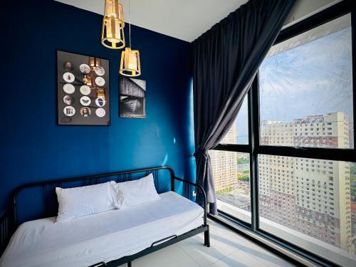 a blue room with a bed and a large window at Urban Suite Cozy Family Homestay at Georgetown by URBAN STAYCATION HENG LOD in Jelutong