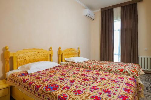 um quarto com 2 camas e uma colcha colorida em Hotel Latif em Bukhara