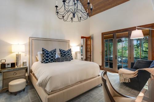 a bedroom with a bed and a chair and a chandelier at Chateau at Elk Spring in Edwards