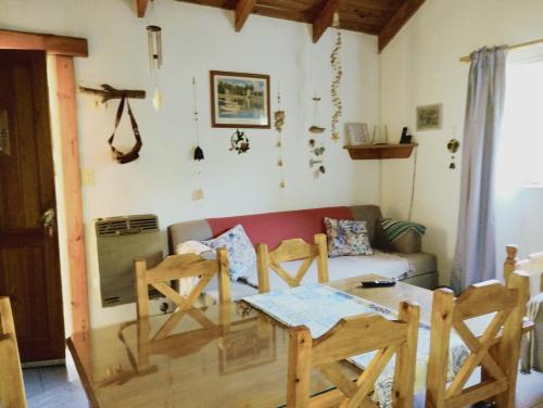 sala de estar con sofá, mesa y sillas en Colibrí House en San Martín de los Andes