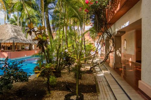 um resort com piscina e palmeiras em Villas Arqueologicas Chichen Itza em Chichén Itzá