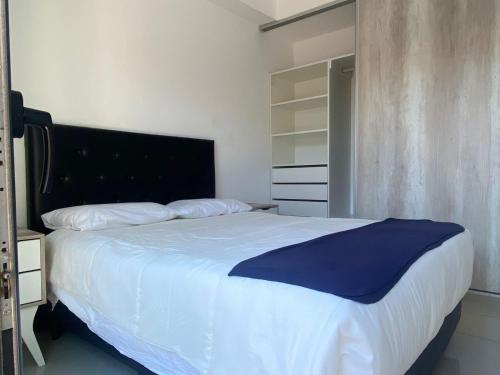 sypialnia z dużym łóżkiem z niebieskim kocem w obiekcie La Palmerita w mieście Villa Carlos Paz