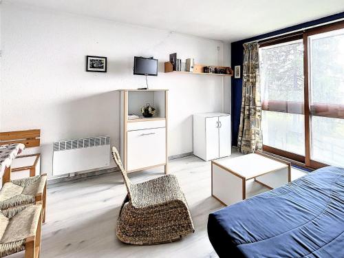 a living room with a bed and a chair at Studio fonctionnel au pied des pistes - FR-1-267-232 in Villarembert