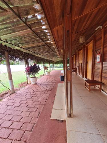 a building with a wooden roof and a brick walkway at POUSADA POR DO SOL in Olímpia