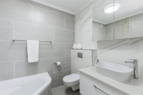 een witte badkamer met een toilet en een wastafel bij Laguna La Crete 9 in Uvongo Beach