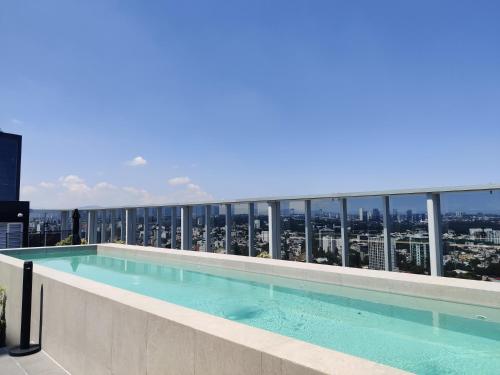 a swimming pool on the roof of a building at Nido x Nomad Las Américas GDL in Guadalajara