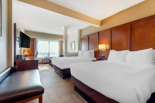 um quarto de hotel com duas camas e uma televisão em Lift Bridge Lodge, Ascend Hotel Collection em Duluth