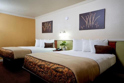 una habitación de hotel con 2 camas en una habitación en Family Garden Inn & Suites en Laredo
