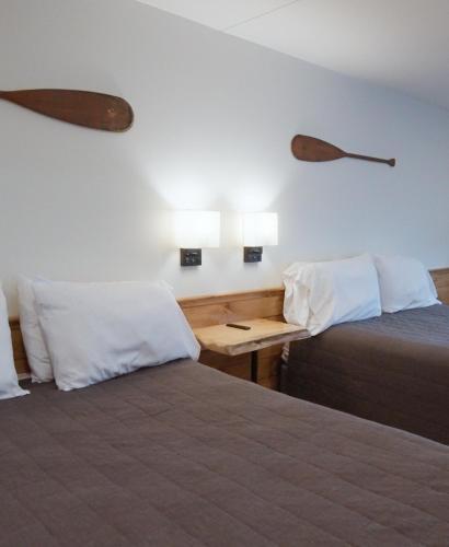 a room with two beds and a table with two lamps at Bingham Motor Inn in Bingham