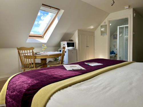 a bedroom with a bed and a table and a window at Priors Oak - A Cosy Studio with Countryside Views in Dorset in Stalbridge