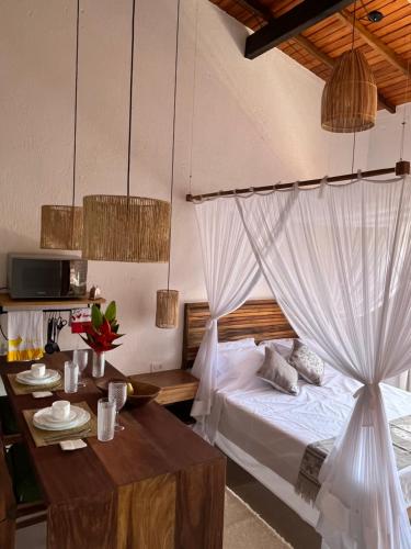 a bedroom with a bed and a table with a tableablish at LOFT café da manhã e piscina ! in Trancoso
