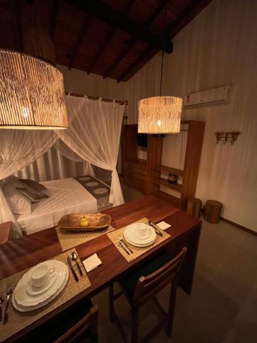 Habitación con mesa de comedor y cama en Estúdio com piscina, en Trancoso