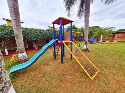 a playground with a slide in a yard at POUSADA POR DO SOL in Olímpia
