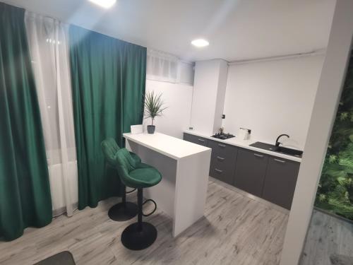 un bagno con bancone bianco e tenda da doccia verde di Apartament Raissa a Turda