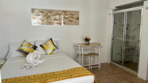 a bedroom with a bed and a glass shower at Tu Casita en Aruba in Palm-Eagle Beach