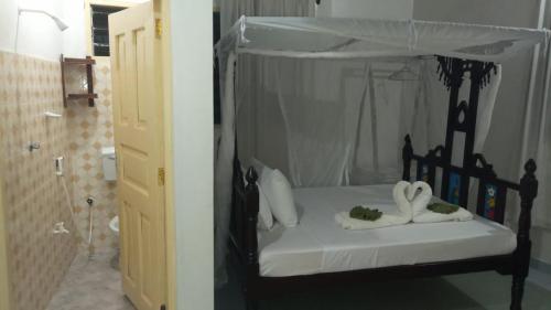 Manama Suites Lamu في لامو: غرفة نوم بسرير اسود عليها مناشف