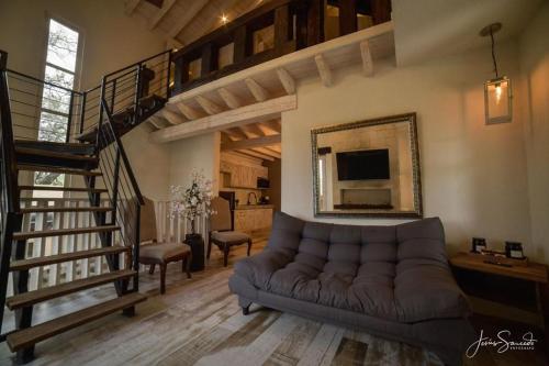 a living room with a couch and a staircase at Suites Campestres Montebello in Bernal