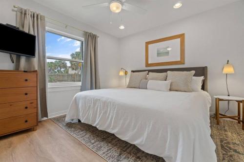 a white bedroom with a large bed and a window at The Sunny Side-Pensacola Beach, 600 feet to Gulf, Private/Heated Pool, Games, Gear in Pensacola Beach
