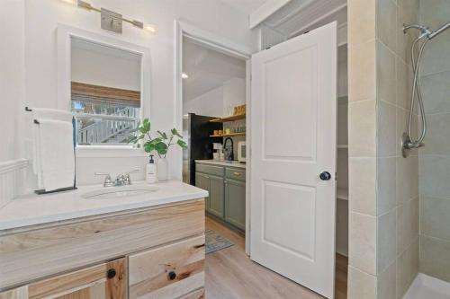 a bathroom with a sink and a shower and a mirror at The Sunny Side-Pensacola Beach, 600 feet to Gulf, Private/Heated Pool, Games, Gear in Pensacola Beach