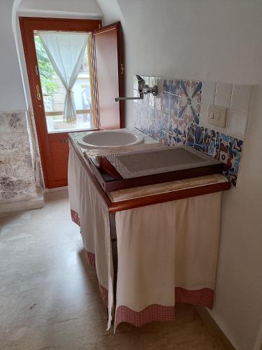 La salle de bains est pourvue d'un lavabo et d'un miroir. dans l'établissement Luxury Trulli sabotino, à Alberobello