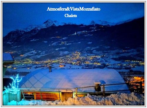 eine Buchhülle mit atmosphärischem Blick auf eine Stadt in der Unterkunft Atmosfera e vista mozzafiato Chalets in Aosta