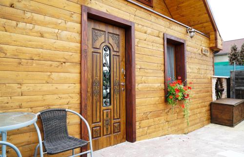 una puerta de madera en una pared de madera con mesa y sillas en Ada, en Rimavská Sobota