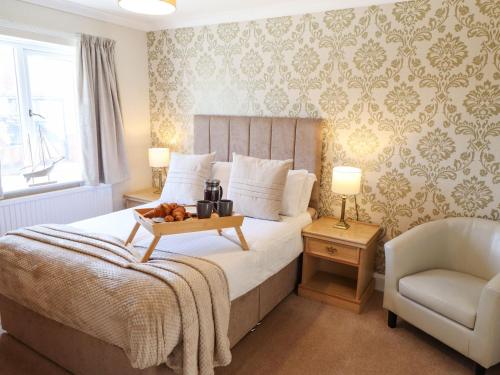 a bedroom with a bed with a tray of fruit on it at Chalfont Lodge in Skegness