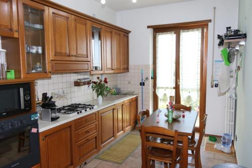 cocina con armarios de madera y mesa de cocina con mesa en In Famiglia, en Biella