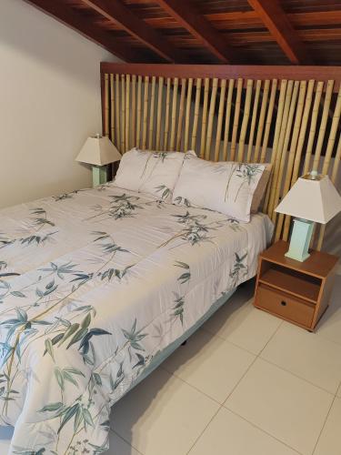 a bedroom with a bed with a wooden headboard at Villa Bonita praia in Palhoça