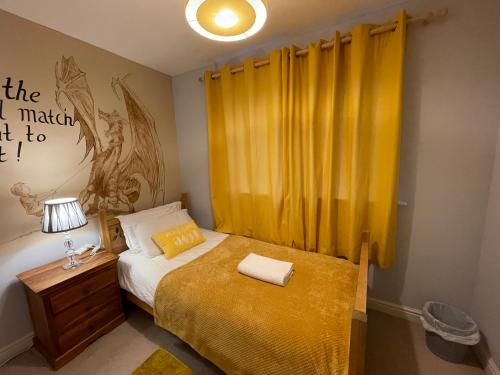 um quarto com uma cama com uma cortina amarela em Holiday Home In Cardiff, Sleeps 8 em Cardiff