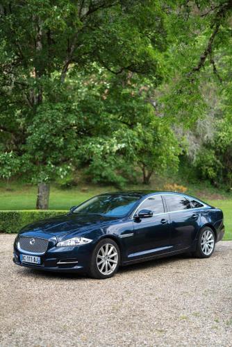 a blue car parked in a gravel parking lot at Château Forge du Roy in Mauzens-et-Miremont