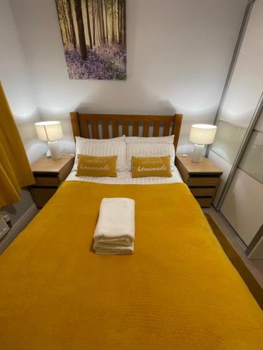 a bedroom with a large yellow bed with two lamps at Holiday Home In Cardiff, Sleeps 8 in Cardiff
