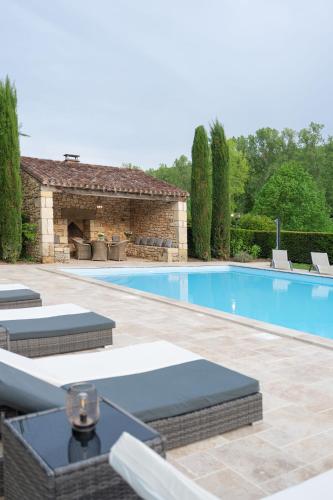 a swimming pool with lounge chairs and a house at Château Forge du Roy in Mauzens-et-Miremont