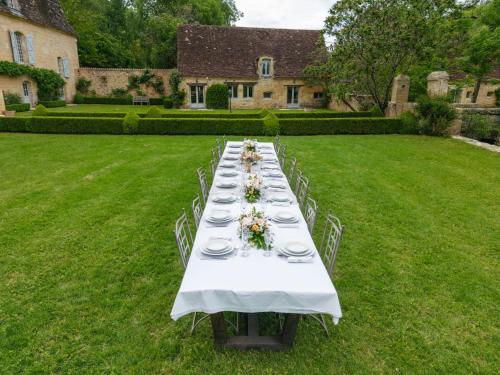 a long table with plates and flowers on a lawn at Château Forge du Roy in Mauzens-et-Miremont
