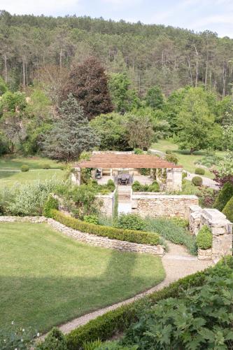 a garden with a stone building and a stone path at Château Forge du Roy in Mauzens-et-Miremont