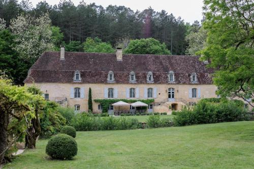 a large stone house with a garden in front of it at Château Forge du Roy in Mauzens-et-Miremont