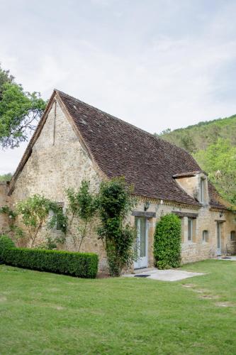 a large stone house with a green yard at Château Forge du Roy in Mauzens-et-Miremont