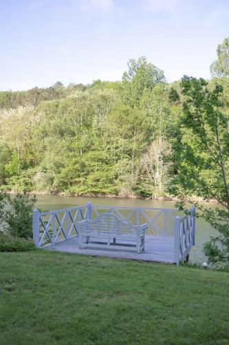 two benches sitting on a bridge over a pond at Château Forge du Roy in Mauzens-et-Miremont
