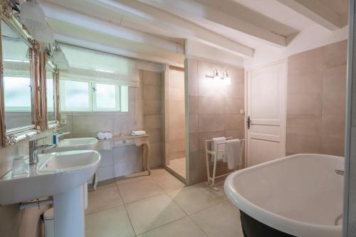 a bathroom with a tub and a sink and a tubermottermott at Château Forge du Roy in Mauzens-et-Miremont