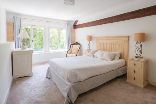 a bedroom with a large white bed and a window at Château Forge du Roy in Mauzens-et-Miremont