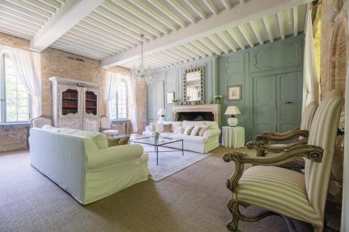 a living room with white furniture and green walls at Château Forge du Roy in Mauzens-et-Miremont