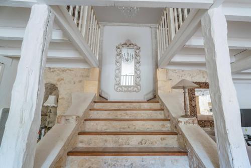 a staircase in a house with white walls and wooden floors at Château Forge du Roy in Mauzens-et-Miremont