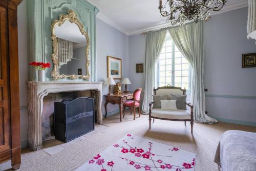 a living room with a fireplace and a mirror at Château Forge du Roy in Mauzens-et-Miremont