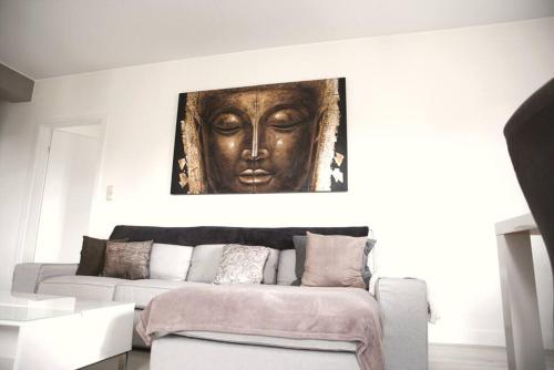 una sala de estar con sofá y una estatua en la pared en Calm and Cozy apartment Bivange, en Livange