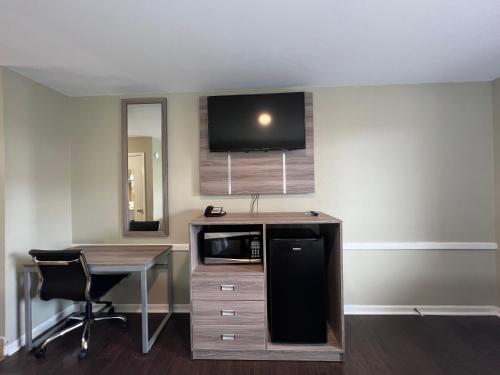 a room with a desk and a tv on a wall at Travelodge by Wyndham Santee in Santee