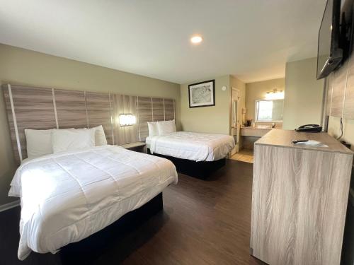 a hotel room with two beds and a desk at Travelodge by Wyndham Santee in Santee