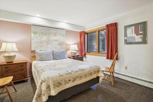 een slaapkamer met een bed en 2 stoelen en een raam bij Highridge B16A Hotel Room Only, Delightful hotel room, sleeps 2 in Killington