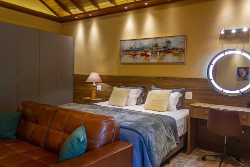 a bedroom with a bed and a couch and a mirror at Don Pascual in Rio de Janeiro